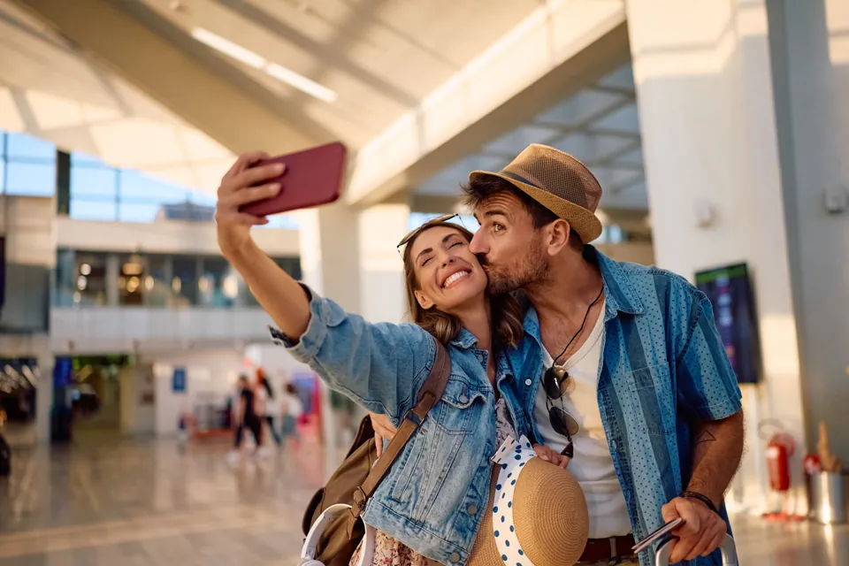 Couple taking a selfie at an airport before their journey